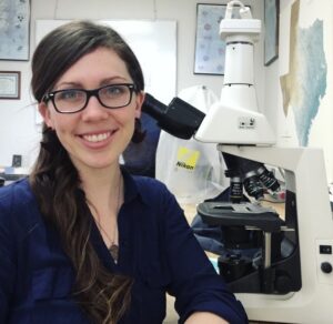 Katelyn McDonough in front of a microscope