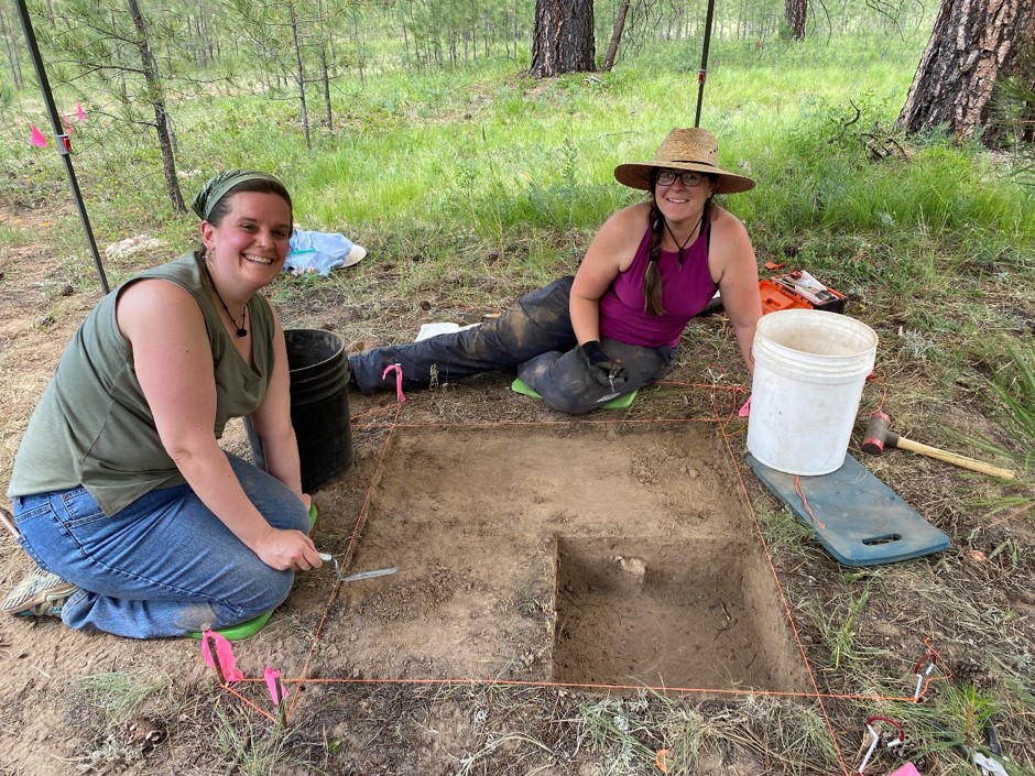 two archaeologists working on a square test unit