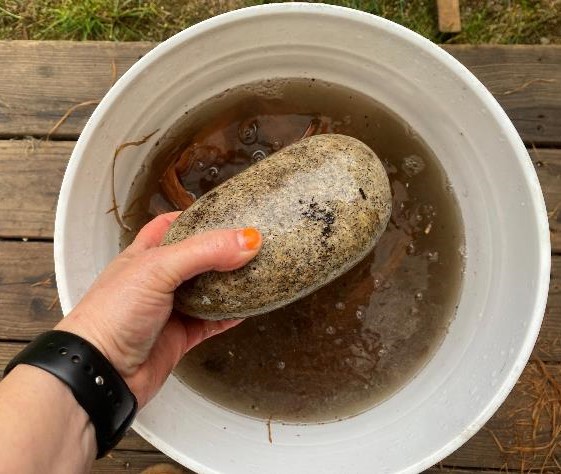 a rock being placed into a bucket