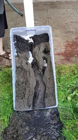plastic bin full of wet eroding soil